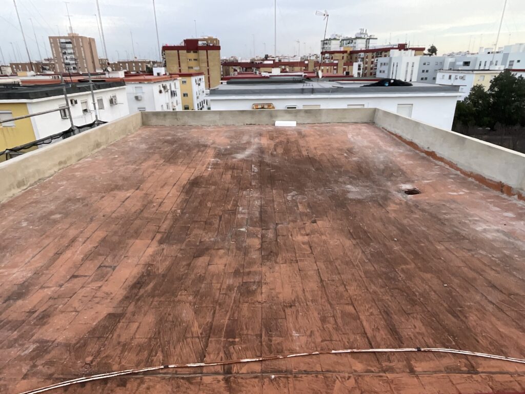 Cubierta plana de Manzana 4 antes de la obra, con el pavimento cerámico desgastado y el pretil original de poca altura