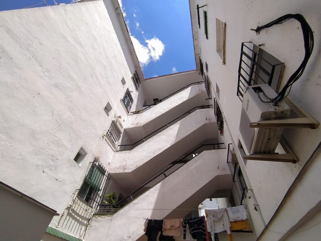 Patio interior de Manzana 4 visto desde abajo, con las galerías de acceso a las viviendas y la ropa tendida